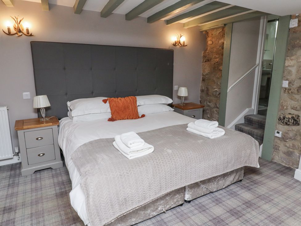 A bedroom with a bed and nightstands at Old Mill (Lucker) Lucker