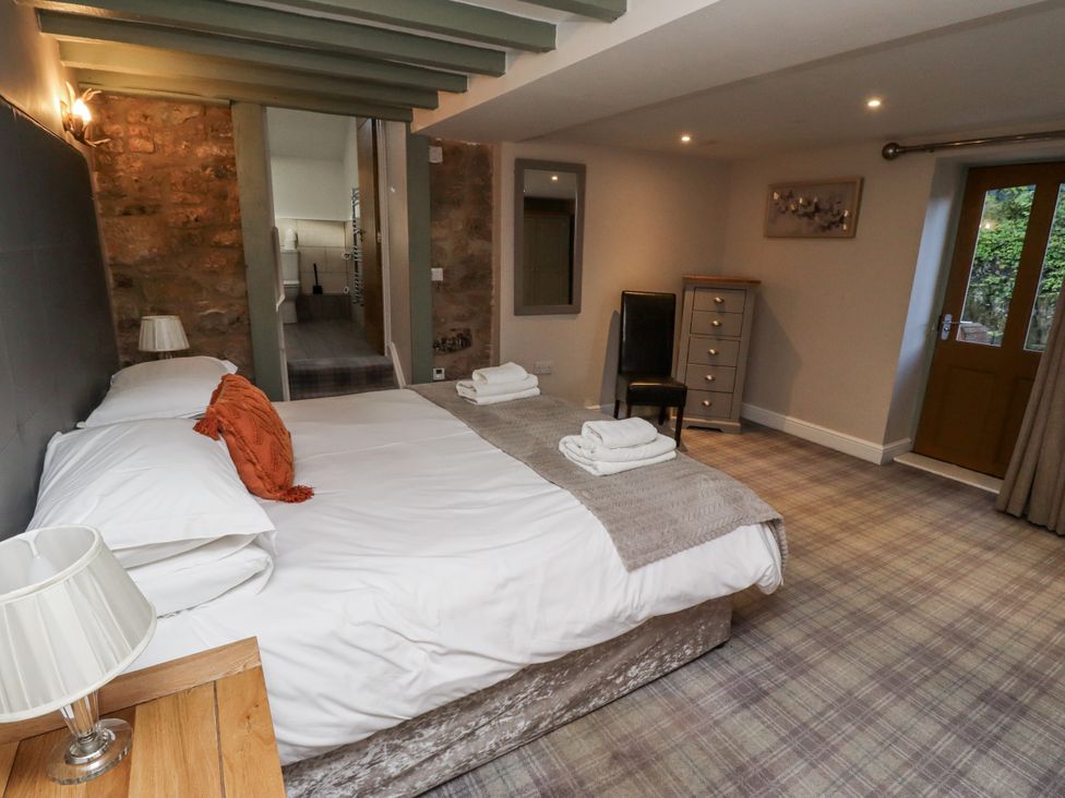 A bedroom with a double bed and a chair at Old Mill (Lucker)