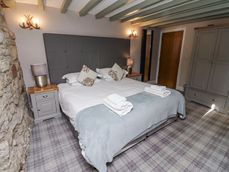 A bedroom with a bed and nightstands at Old Mill (Lucker) Lucker