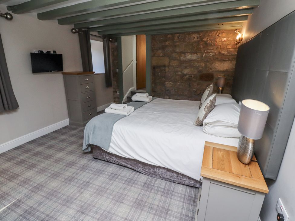A bedroom with a bed and dresser at Old Mill in Lucker