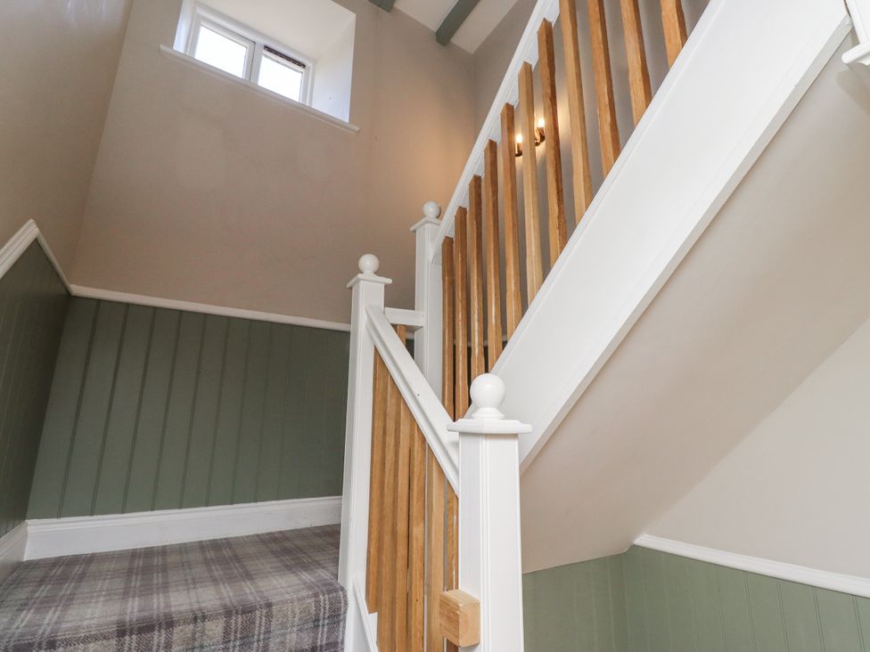 A staircase with wooden banister and window at Old Mill (Lucker) Lucker
