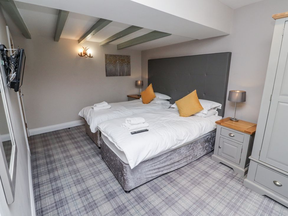 A bedroom with twin beds and a television at Old Mill (Lucker) in Lucker