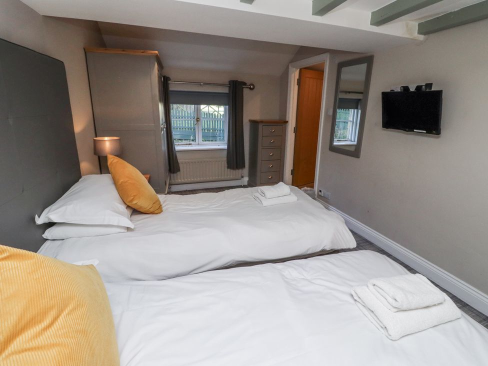 A bedroom with two beds and a television at Old Mill in Lucker