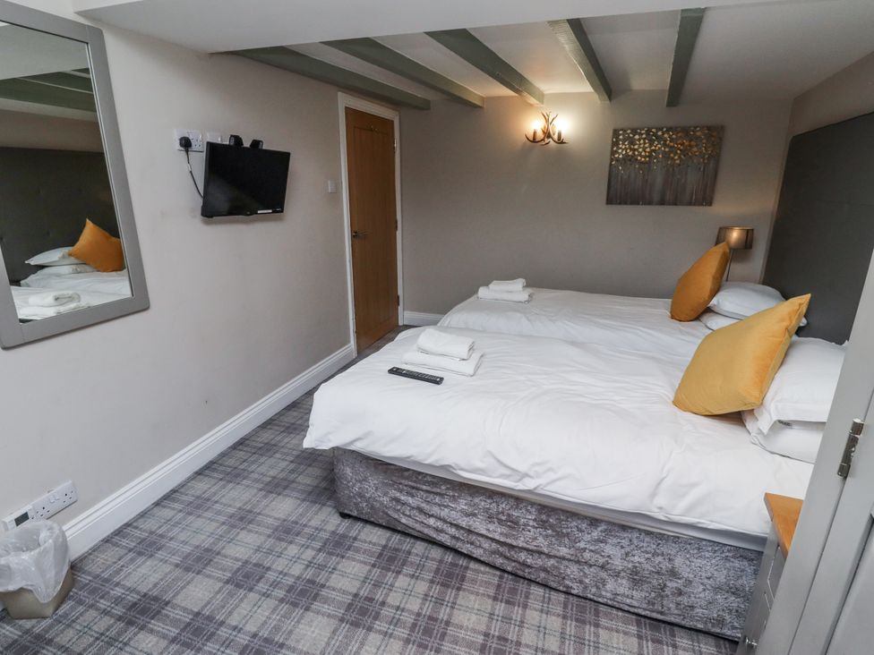 A bedroom with two beds and a television at Old Mill in Lucker