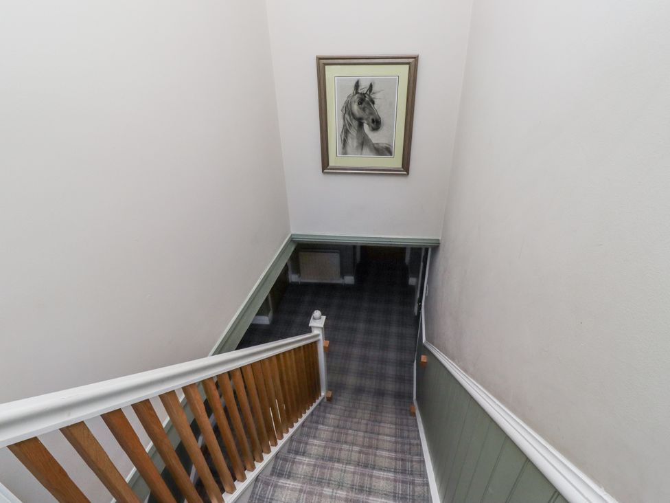 A staircase with a horse portrait and plaid flooring at Old Mill (Lucker)