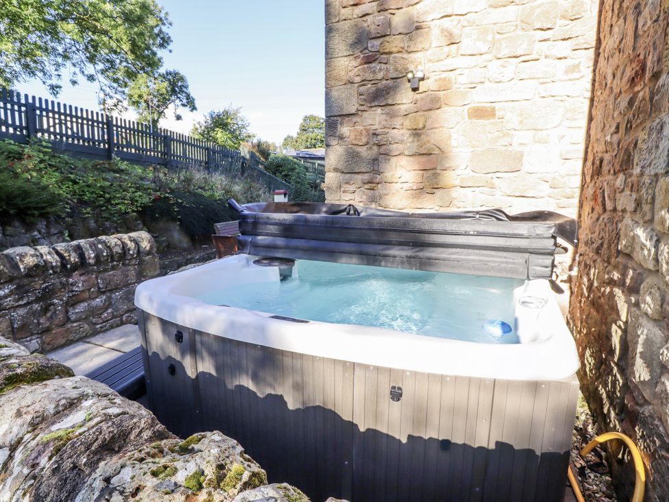 A hot tub in a garden area at Old Mill (Lucker) Lucker