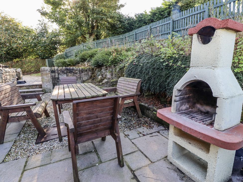 A garden with a table, chairs, and barbecue grill at Old Mill (Lucker) Lucker