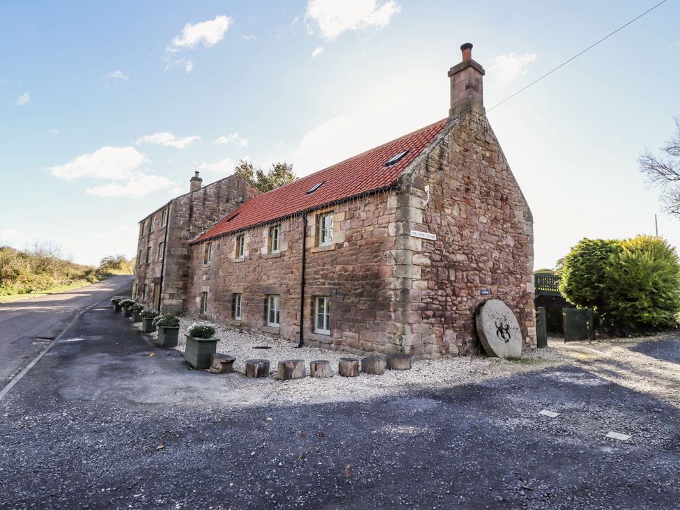 A house with a gravel pathway and plants at Millstone in Lucker