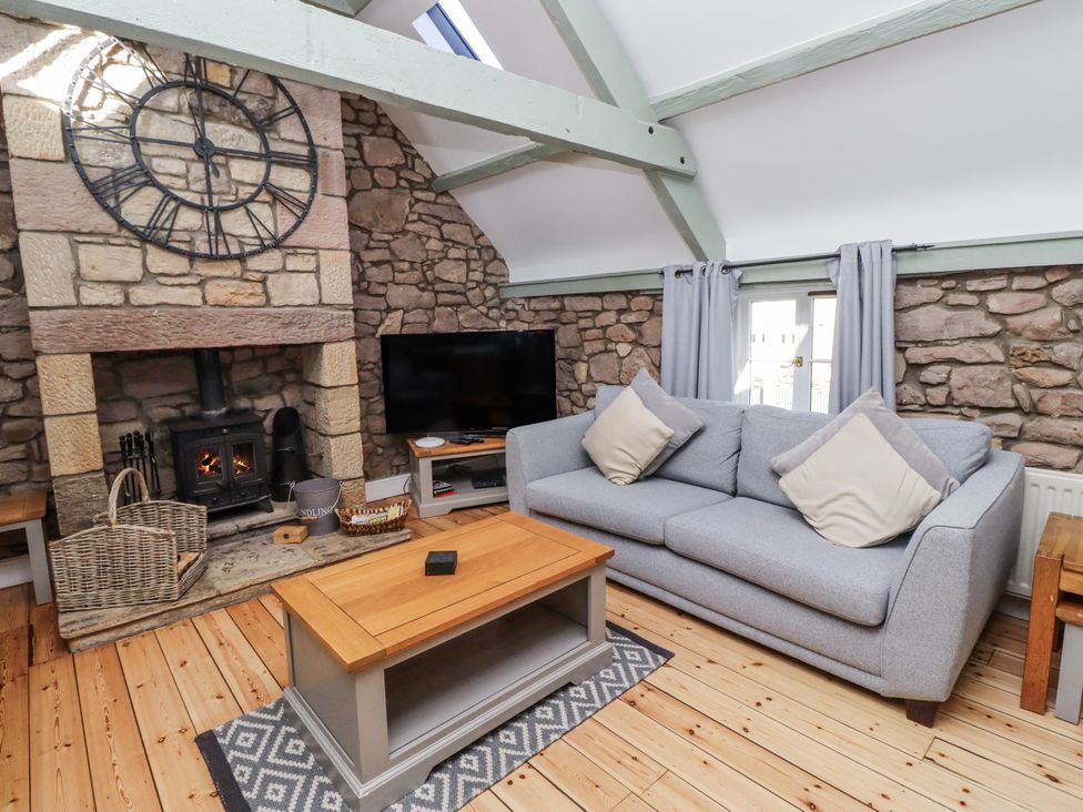 A living room with a sofa and fireplace at Millstone in Lucker