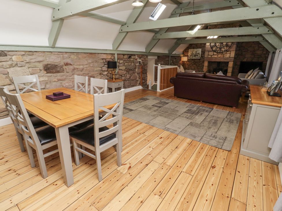 A living room with a dining area and sofa at Millstone in Lucker
