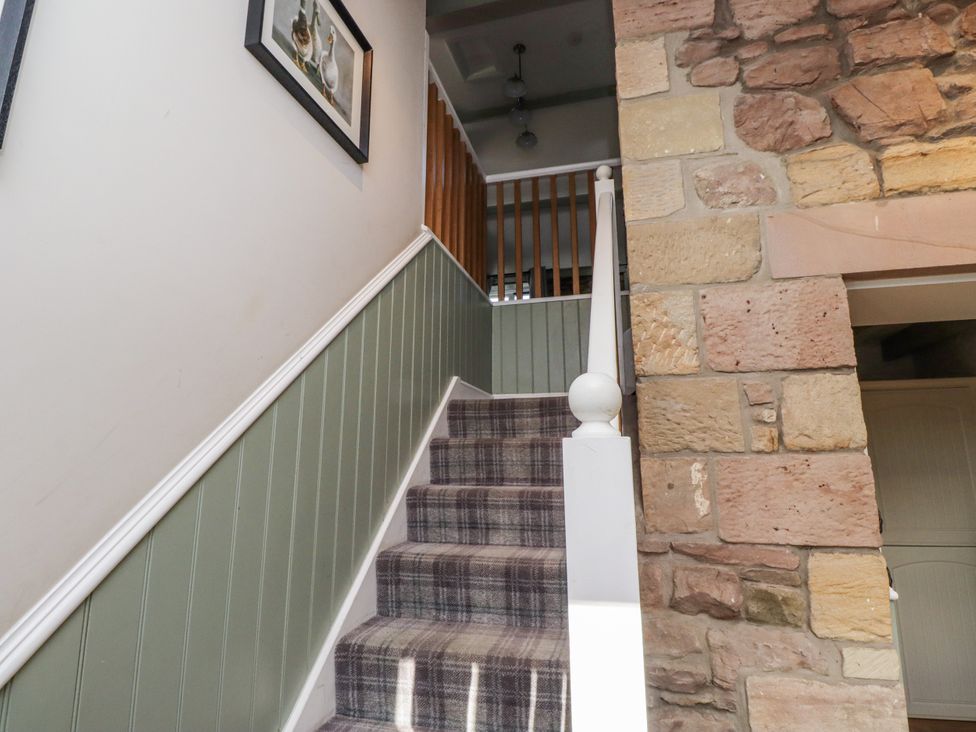 A staircase with carpet and stone wall at Millstone in Lucker