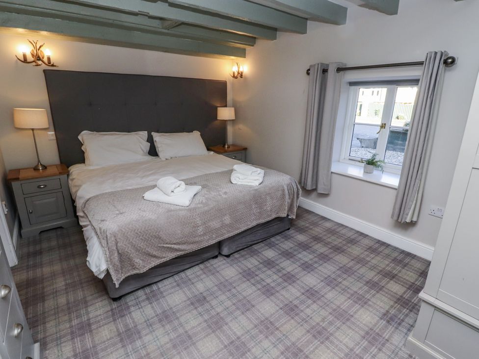 A bedroom with a bed and bedside tables at Millstone in Lucker