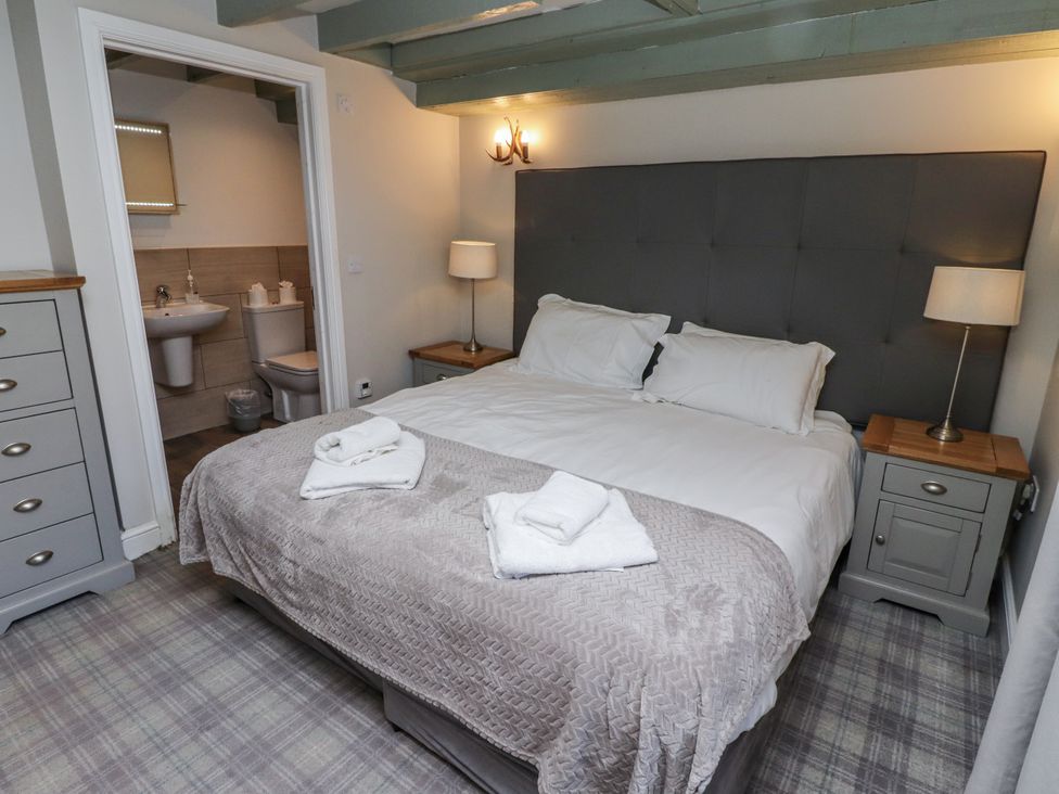 A bedroom with a bed and en-suite bathroom at Millstone in Lucker
