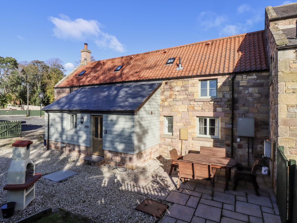 An outdoor area with a house, table and chairs at Millstone in Lucker