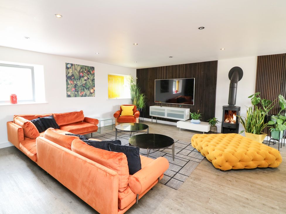 A living room with orange sofas and a fireplace at Hayloft in Scampton