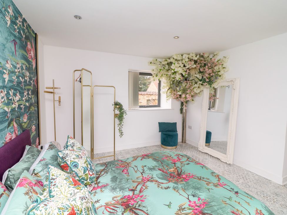 A bedroom with a bed and floral decoration at Hayloft in Scampton