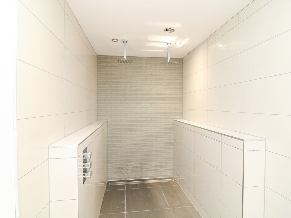A bathroom with shower and tiled walls at Hayloft in Scampton