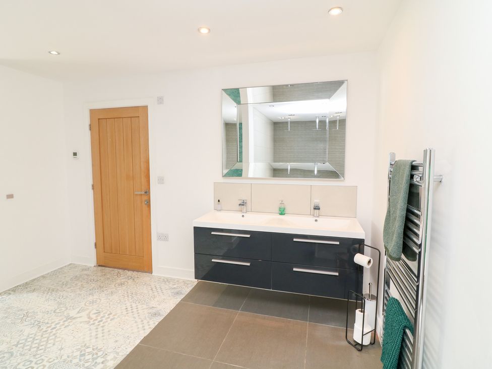 A bathroom with a sink and mirror at Hayloft in Scampton
