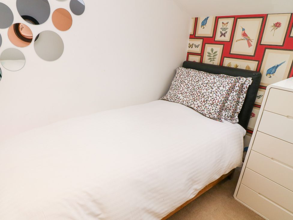 A bedroom with a bed and wall art at Hayloft in Scampton