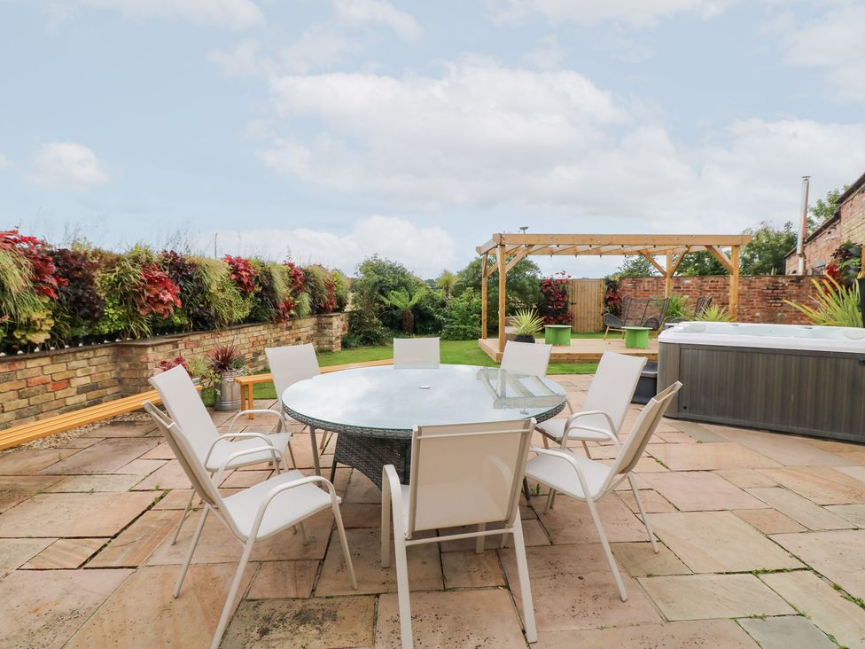 A garden with a table and chairs at Hayloft in Scampton