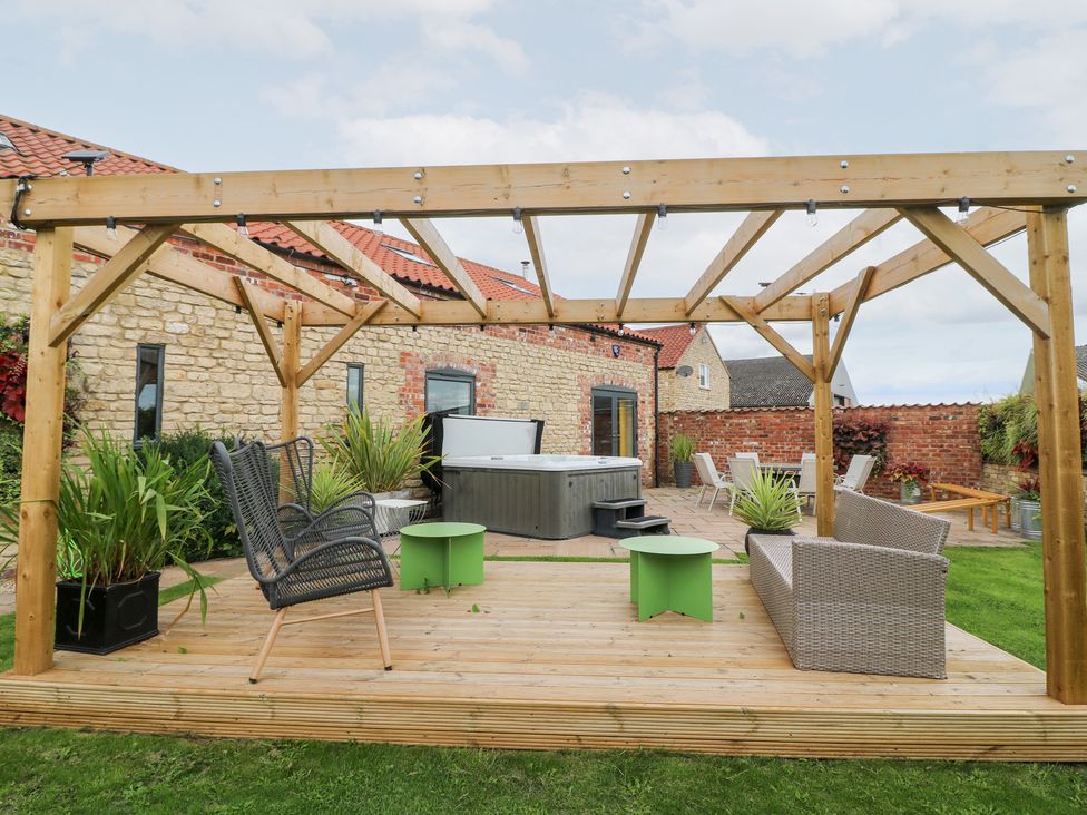 A garden with outdoor seating and a hot tub at Hayloft in Scampton