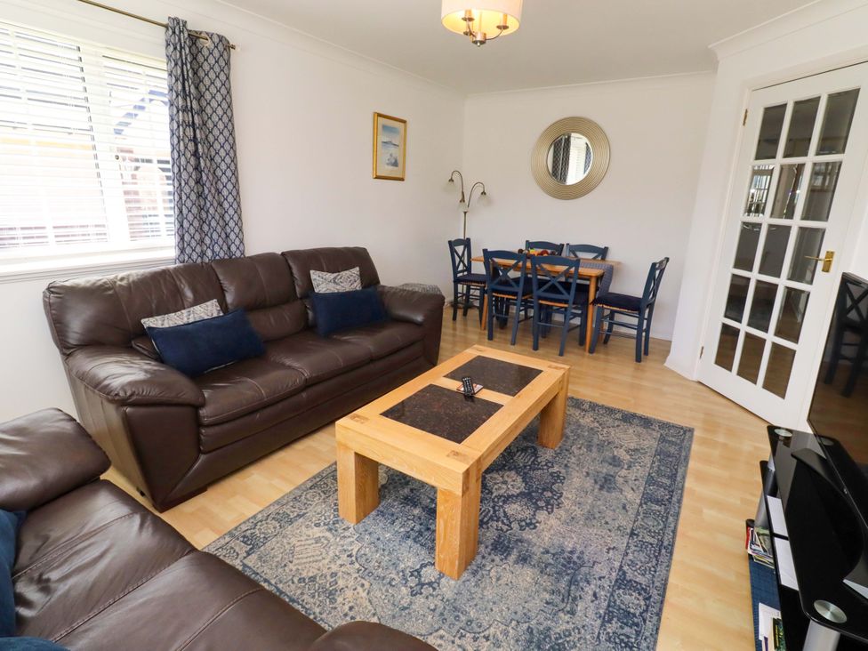 A living room with a sofa and dining table at 6 Westview in Embleton