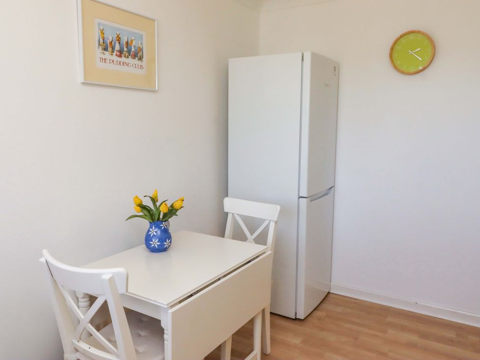 A kitchen with a table and chairs and a refrigerator at 6 Westview Embleton
