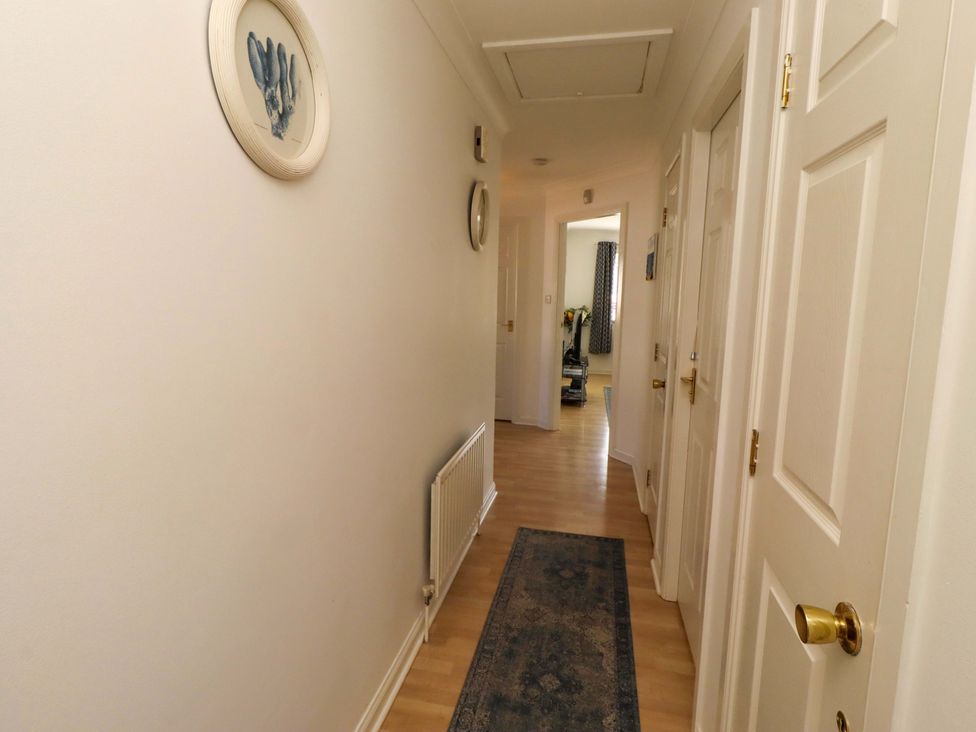 A hallway with doors and a radiator at 6 Westview in Embleton