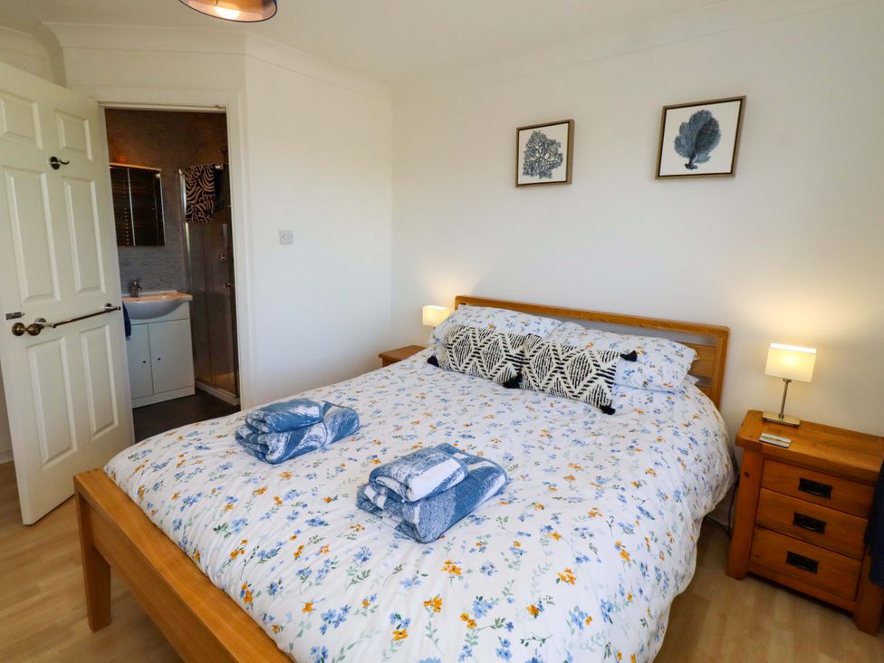 A bedroom with a bed and nightstands at 6 Westview in Embleton