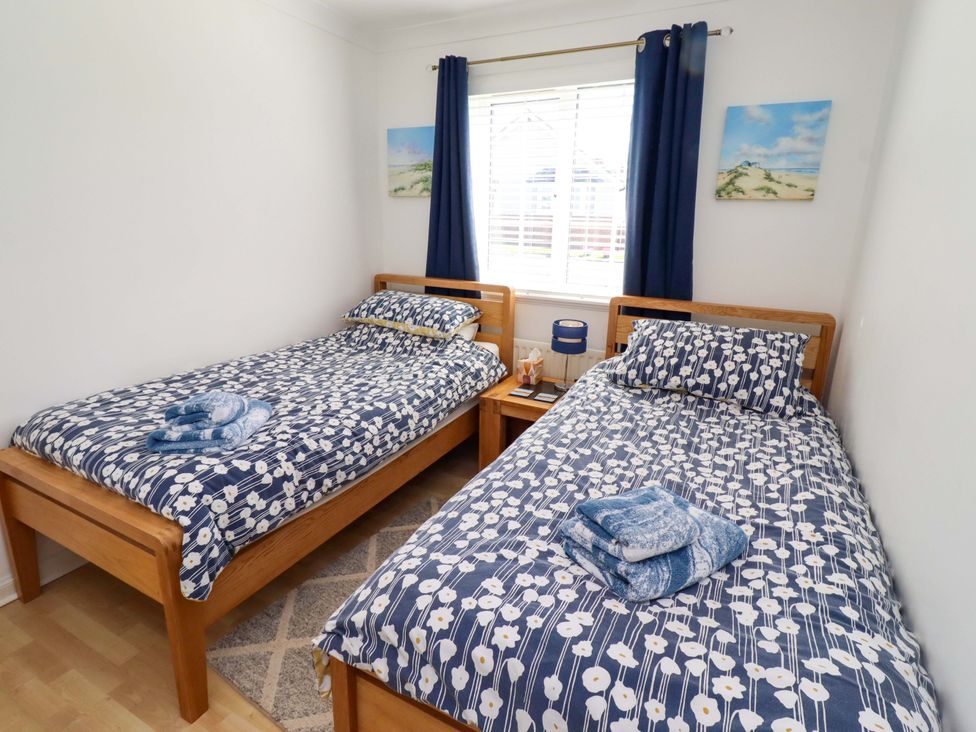 A bedroom with two beds and bedside tables at 6 Westview in Embleton
