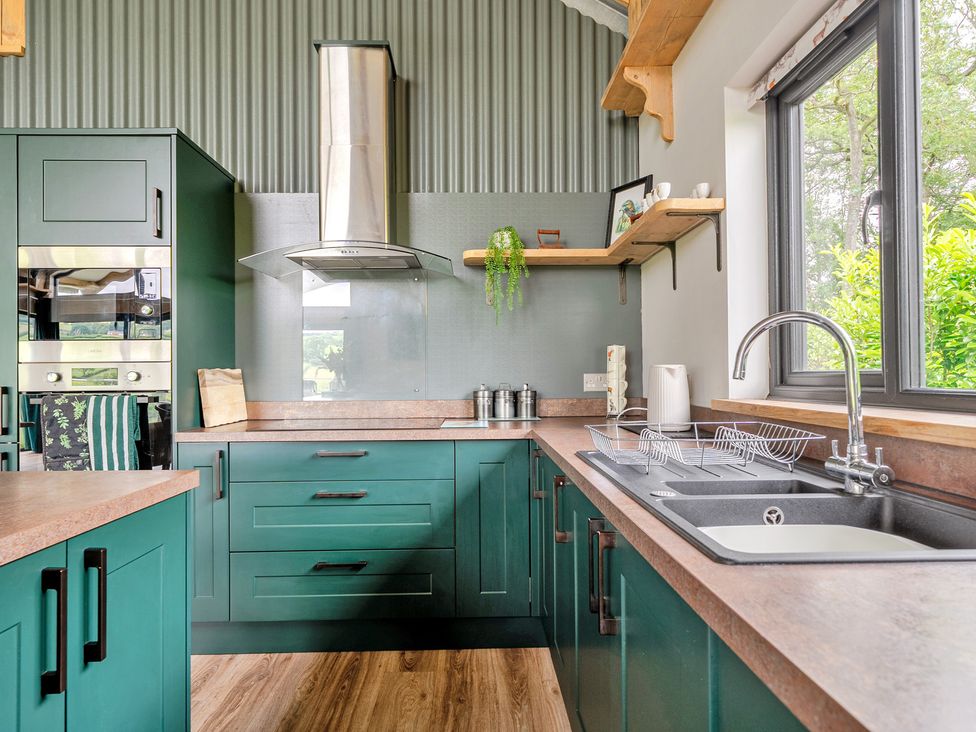 A kitchen with cabinets and a sink at Bwncath in Garthmyl