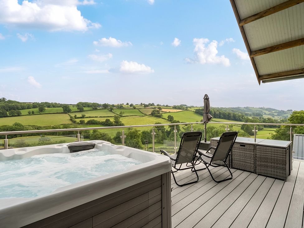 An outdoor area with a hot tub and chairs at Bwncath in Garthmyl