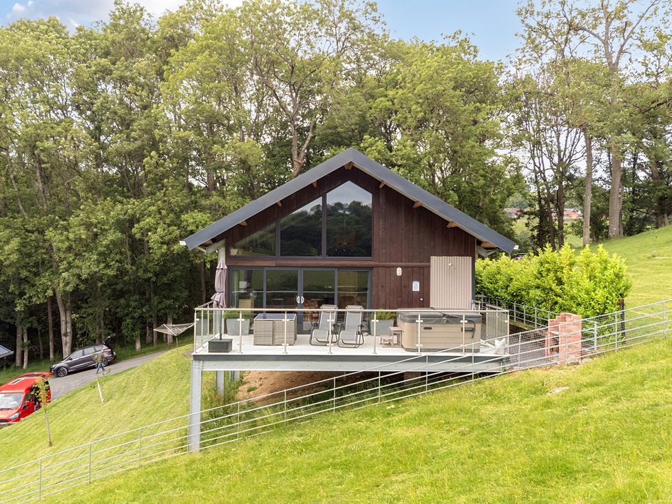 A house with a deck and hot tub at Bwncath in Garthmyl