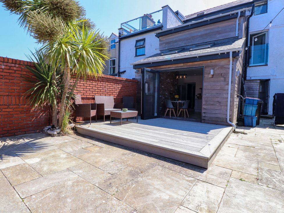 A garden with decking and seating area at Ty Haul Rhosneigr