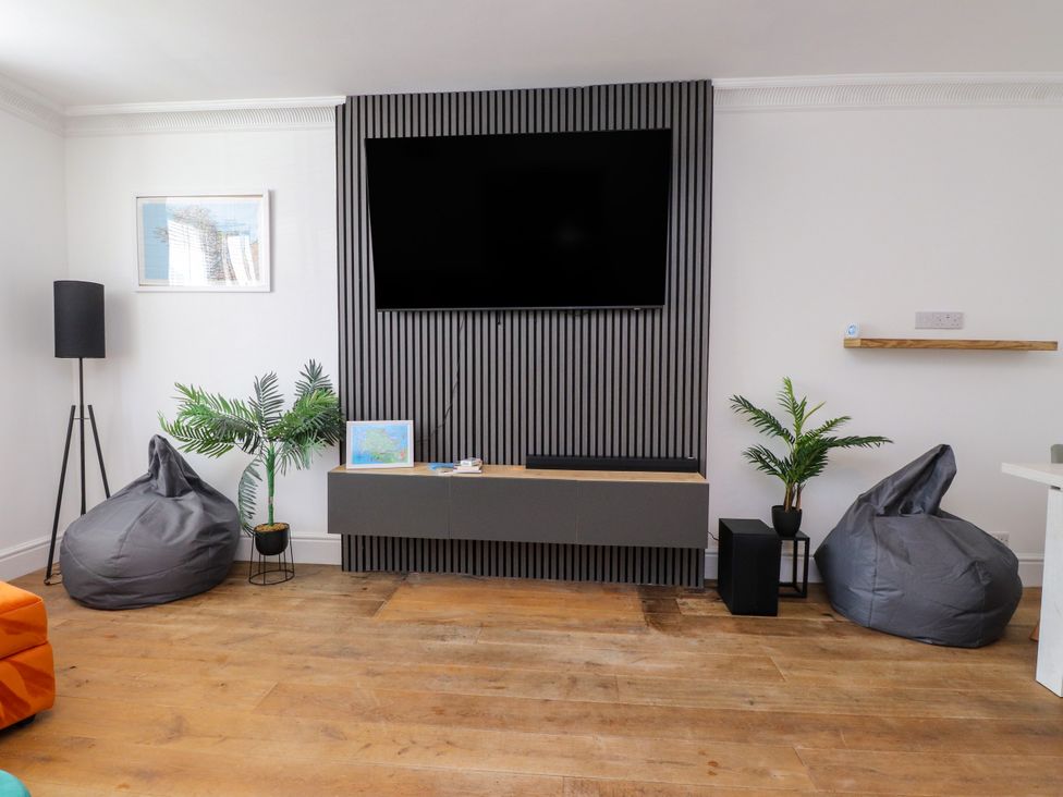 A living room with a television and bean bag chairs at Ty Haul in Rhosneigr