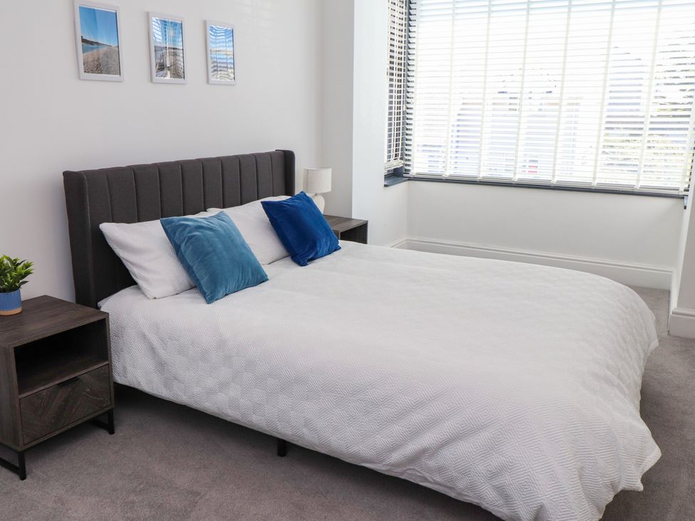 A bedroom with a bed and nightstand at Ty Haul in Rhosneigr