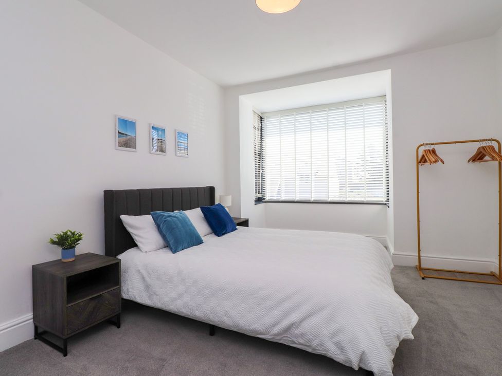 A bedroom with a bed and nightstand at Ty Haul in Rhosneigr