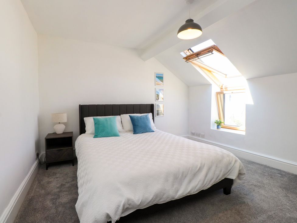 A bedroom with a bed and window at Ty Haul in Rhosneigr