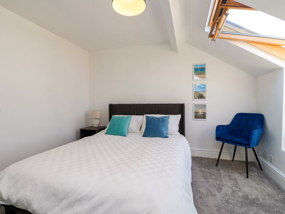 A bedroom with a bed and nightstand at Ty Haul in Rhosneigr
