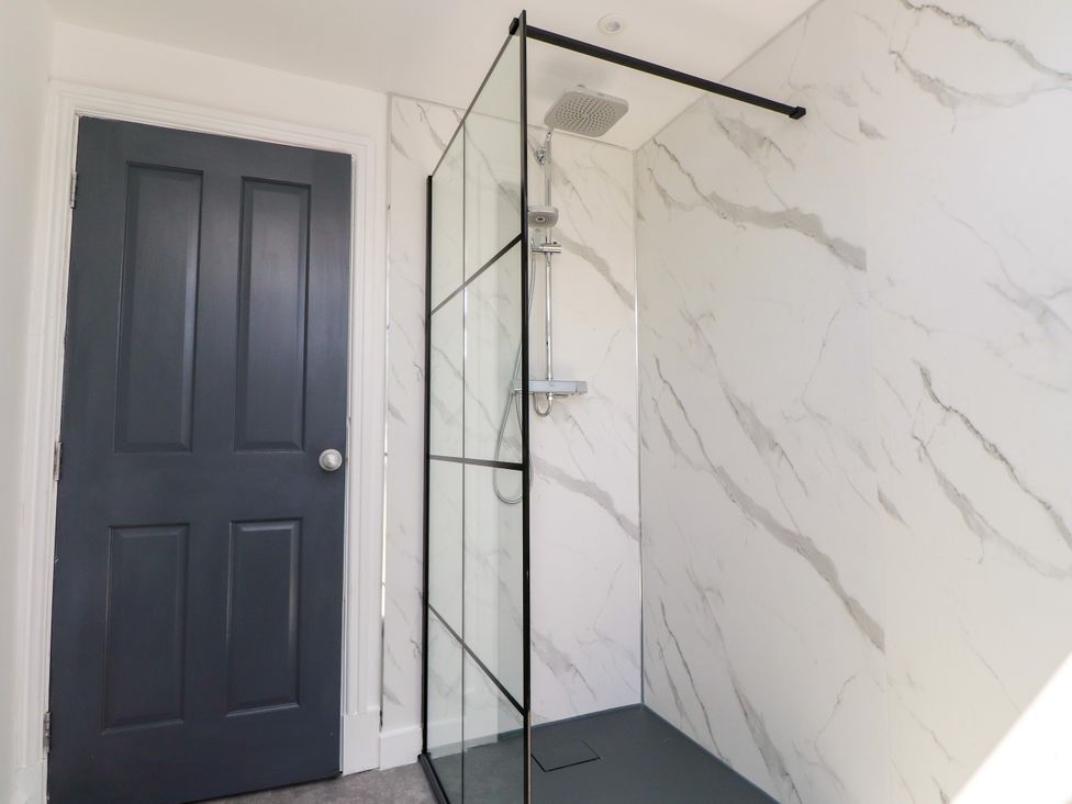 A bathroom featuring a shower and a door at Ty Haul in Rhosneigr