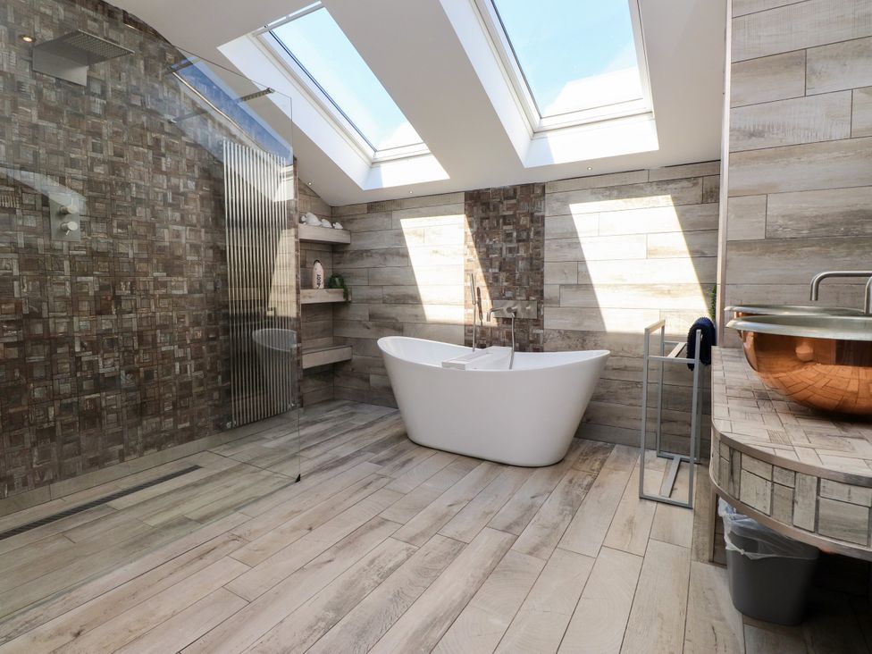 A bathroom with a shower and bathtub at Ty Haul in Rhosneigr