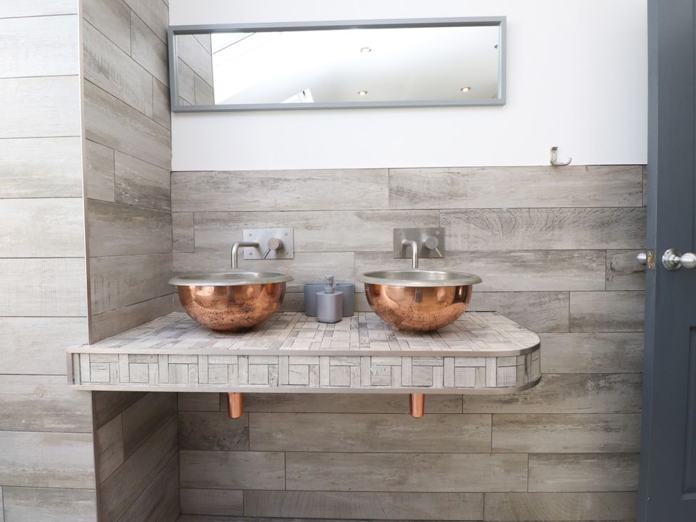 A bathroom with double sinks and a mirror at Ty Haul in Rhosneigr