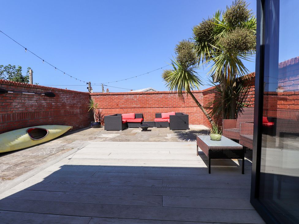 An outdoor area with seating and a kayak at Ty Haul in Rhosneigr