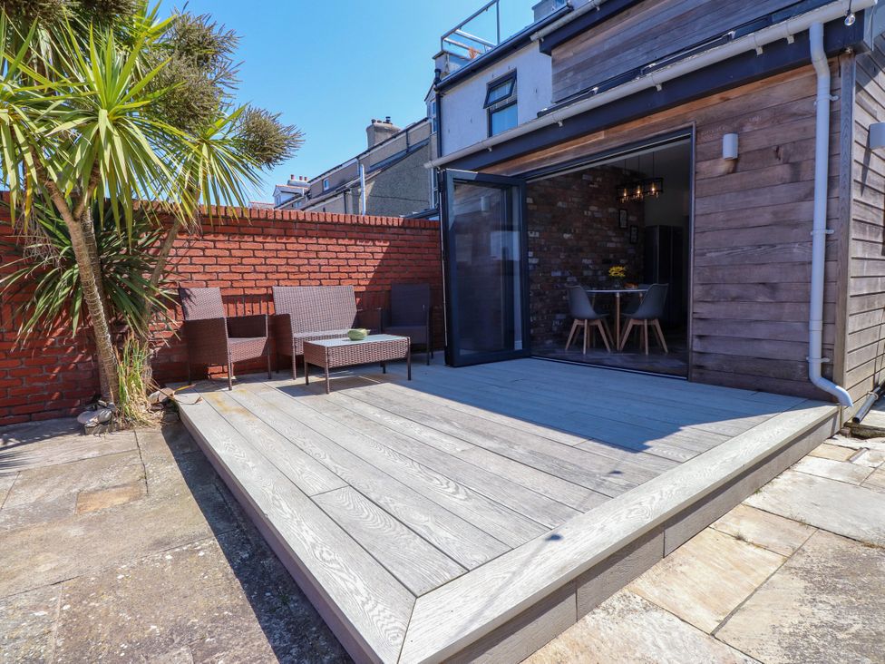 An outdoor area with a patio, table, and chairs at Ty Haul in Rhosneigr