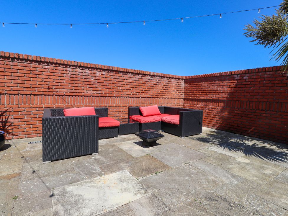 An outdoor seating area with a coffee table at Ty Haul in Rhosneigr