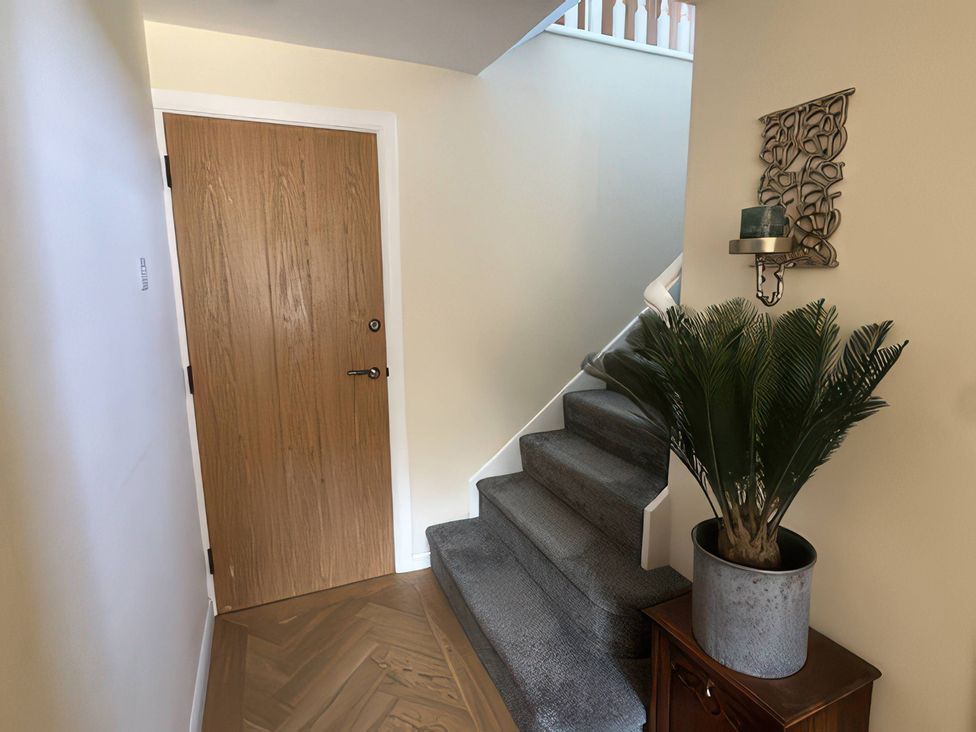 A hallway with a staircase and plant at How Hill Farm Cottage in Greystoke