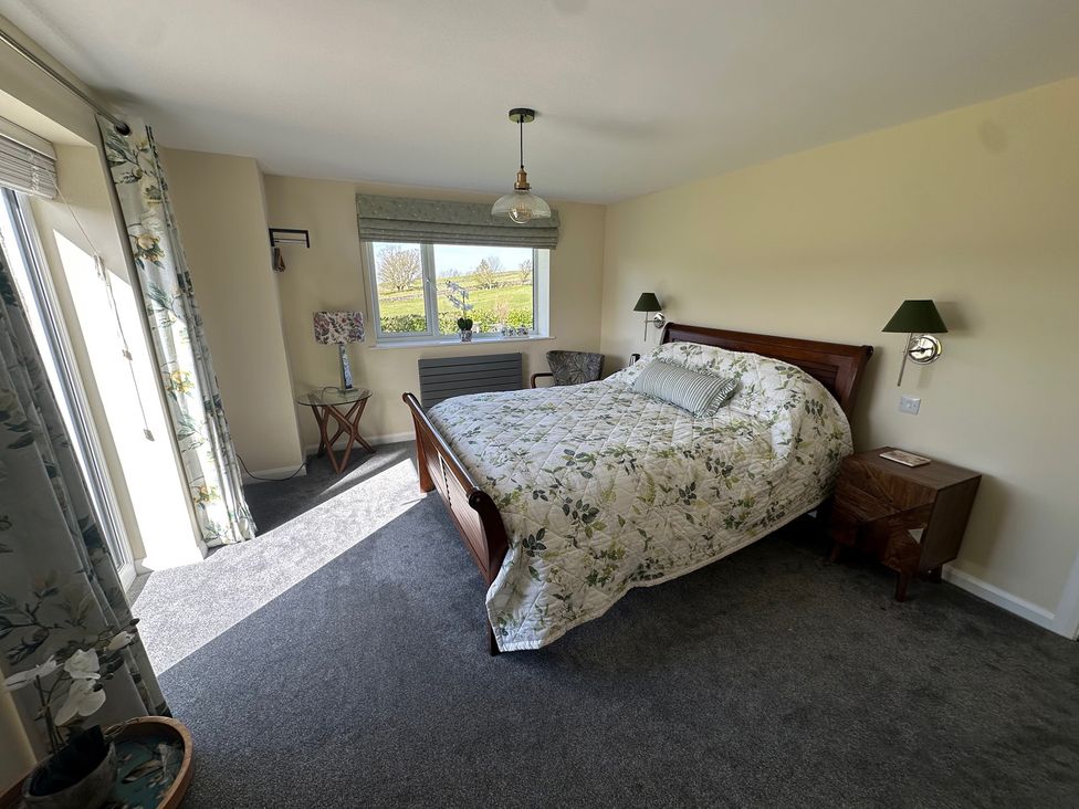 A bedroom with a bed and nightstand at How Hill Farm Cottage in Greystoke