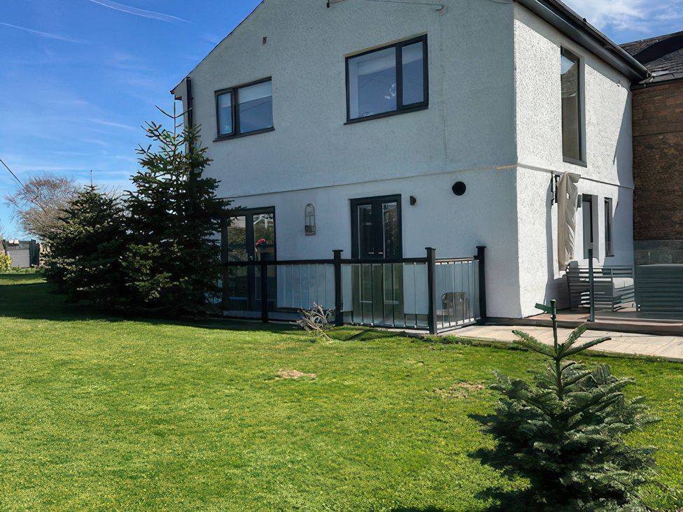 A house with a balcony and trees at How Hill Farm Cottage in Greystoke