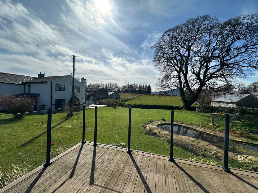 An outdoor area with a deck and garden at How Hill Farm Cottage in Greystoke
