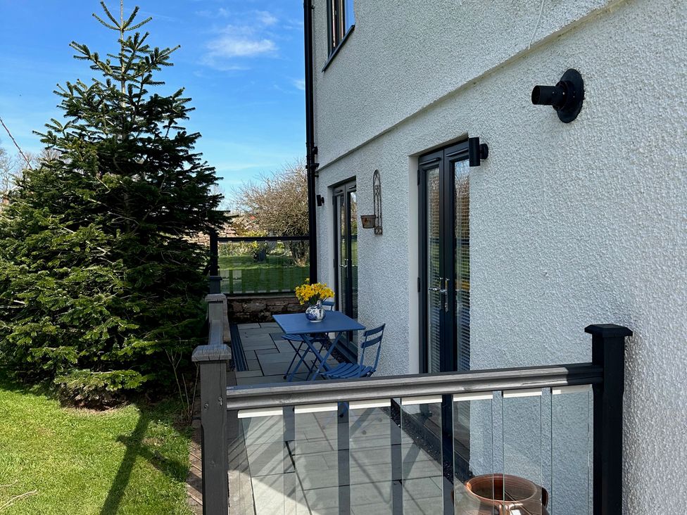 An outdoor area with a table and chairs at How Hill Farm Cottage in Greystoke